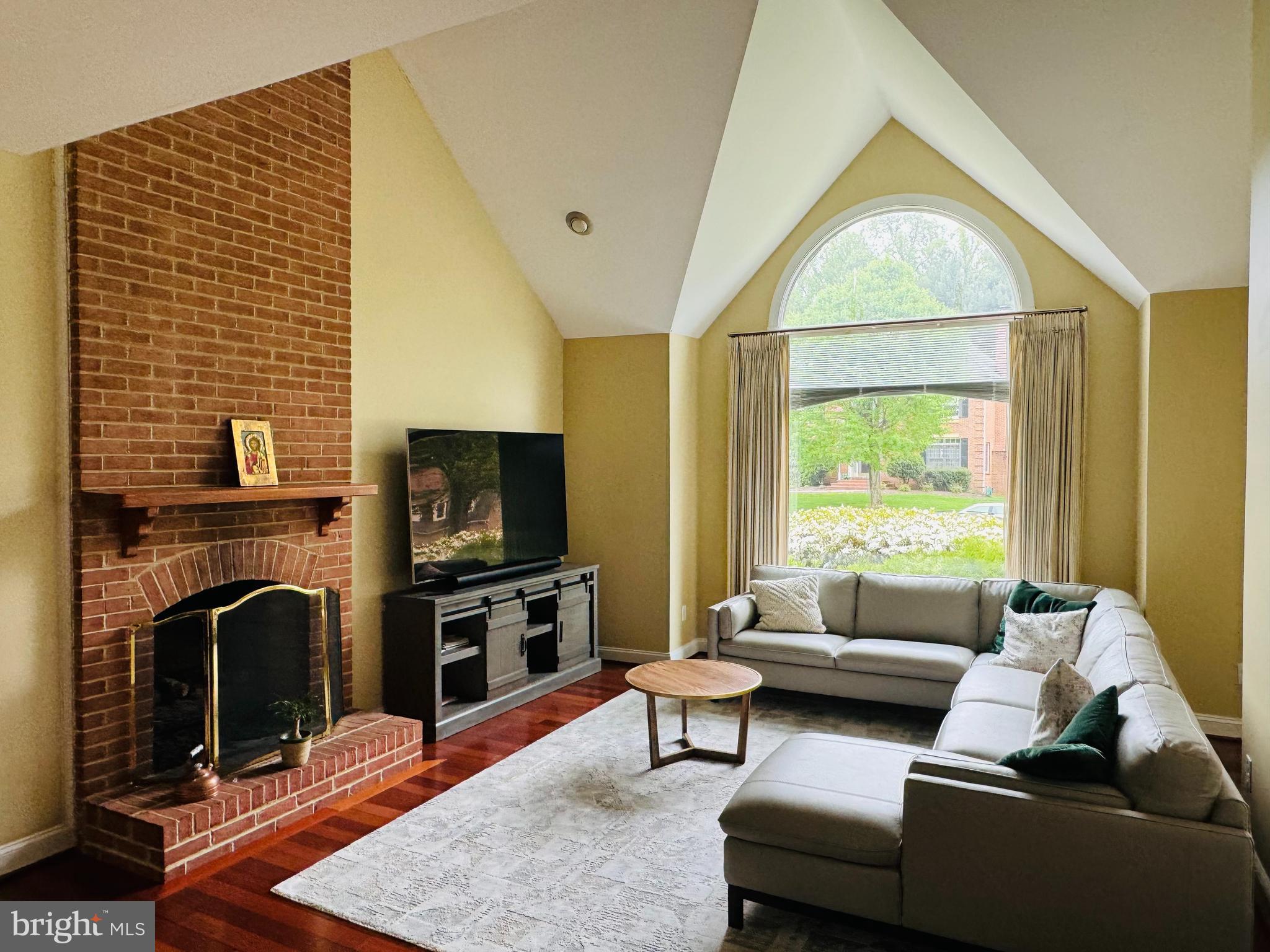 9706 Middleton Ridge Road Vienna, VA 22182 - Photo 4 of 17 a living room with furniture a fireplace and a flat screen tv
