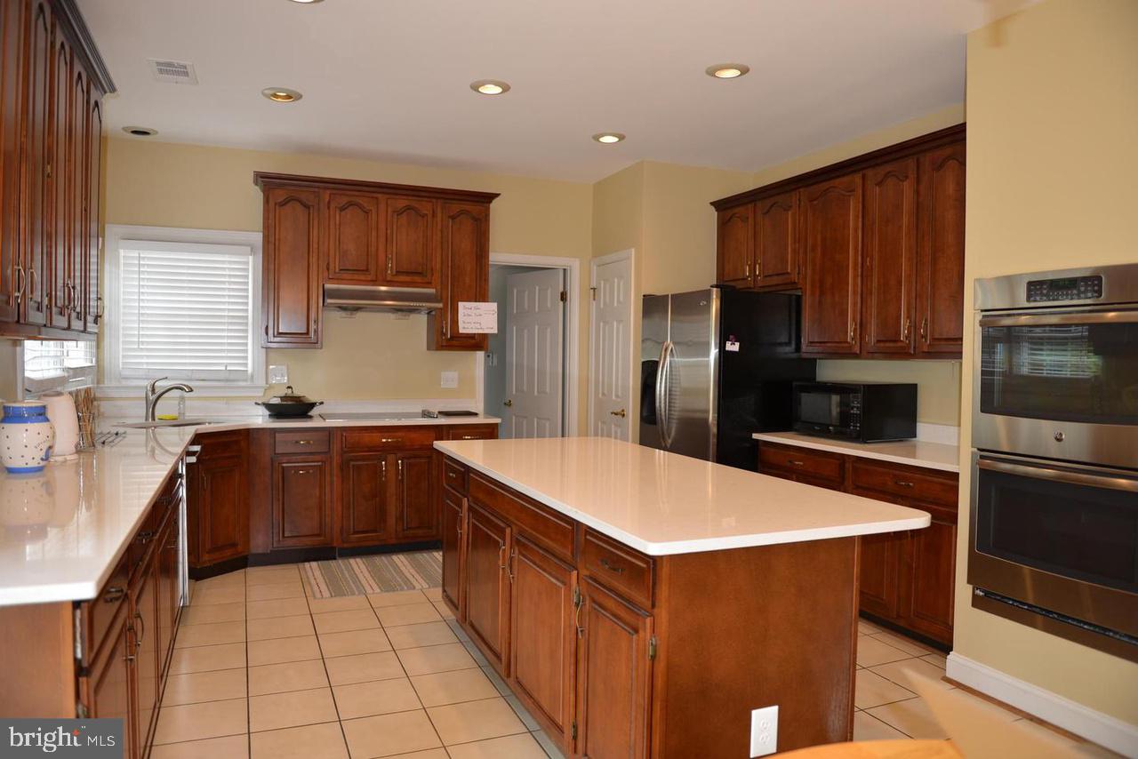 9706 Middleton Ridge Road Vienna, VA 22182 - Photo 10 of 17 a kitchen with stainless steel appliances a refrigerator sink and cabinets