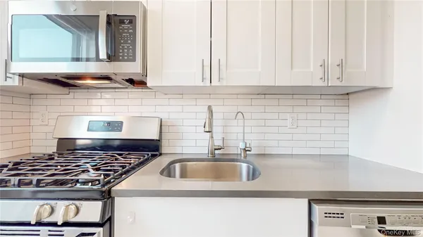 a kitchen with granite countertop a sink and a stove
