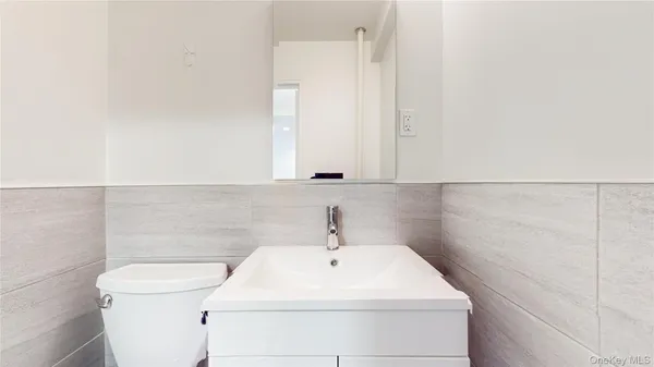 a bathroom with a sink a toilet and a mirror