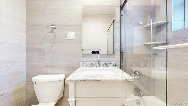 a bathroom with a granite countertop sink a toilet and shower