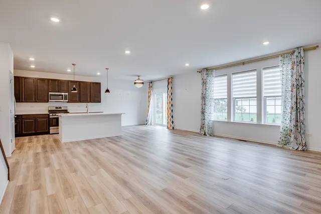 a view of kitchen with wooden floor and electronic appliances