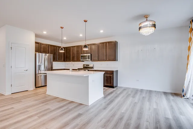 a view of kitchen with granite countertop cabinets and refrigerator