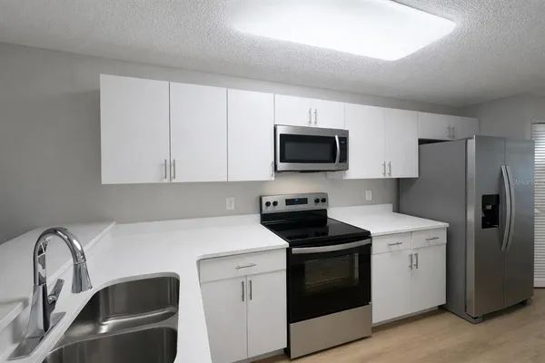 a kitchen with stainless steel appliances a stove microwave and sink
