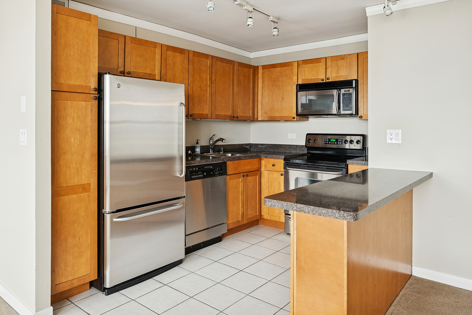 655 West Irving Park Road, Unit 3706 Chicago, IL 60613 - Photo 7 of 16 a kitchen with stainless steel appliances granite countertop a refrigerator a stove a sink and a microwave