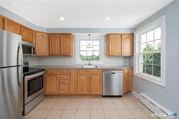 a kitchen with stainless steel appliances granite countertop a refrigerator sink and microwave