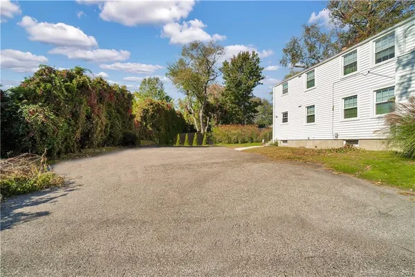 a view of house with yard and trees in the background