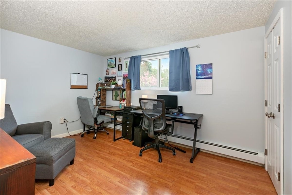 25 Clark's Road, Unit 101 Amesbury, MA 01913 - Photo 10 of 32 a view of a workspace with lounge chair and a window
