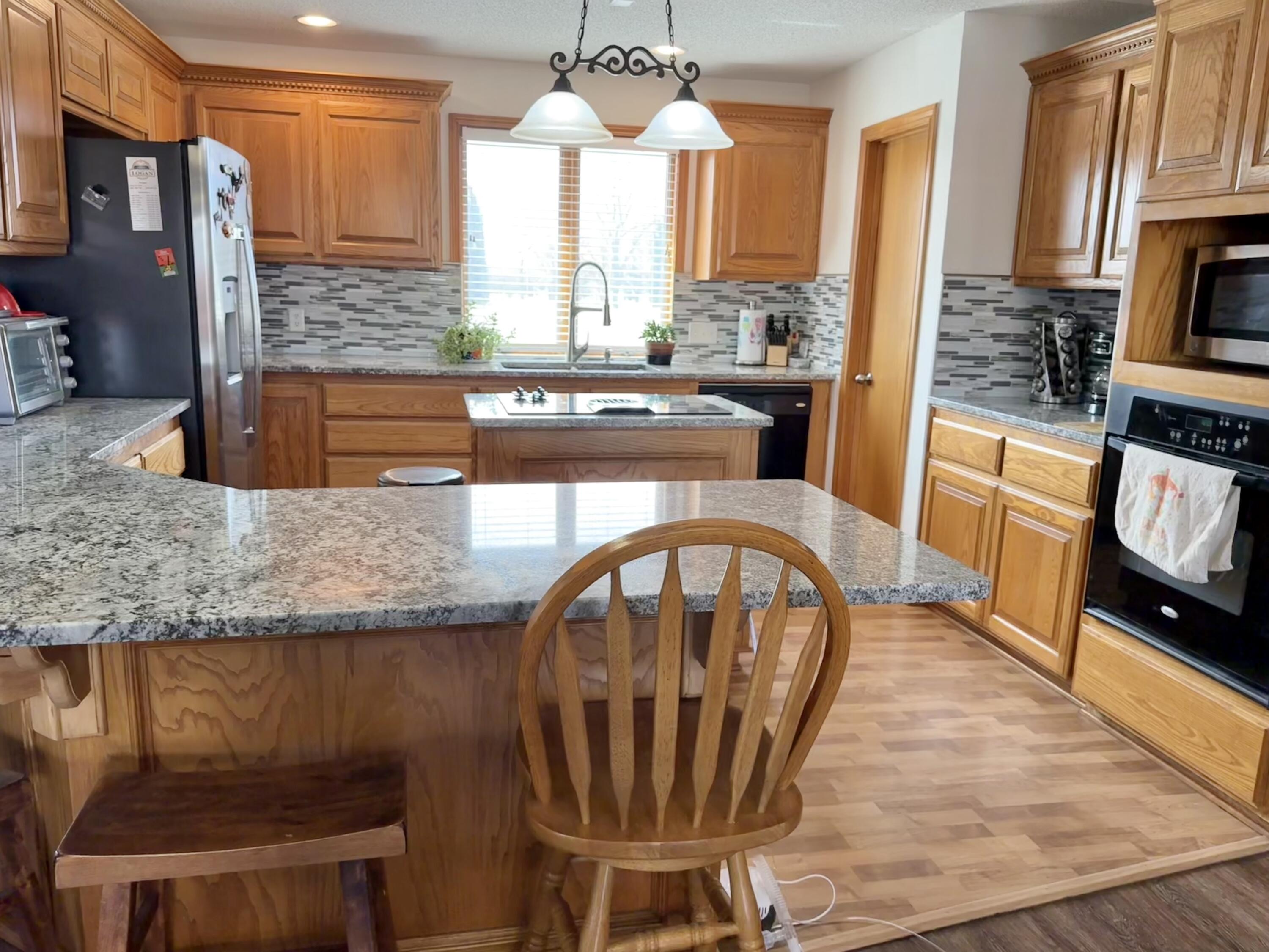 19 Ridgeview Farwell, TX 79325 - Photo 14 of 40 a kitchen with stainless steel appliances granite countertop a stove a sink and a dining table with granite countertops