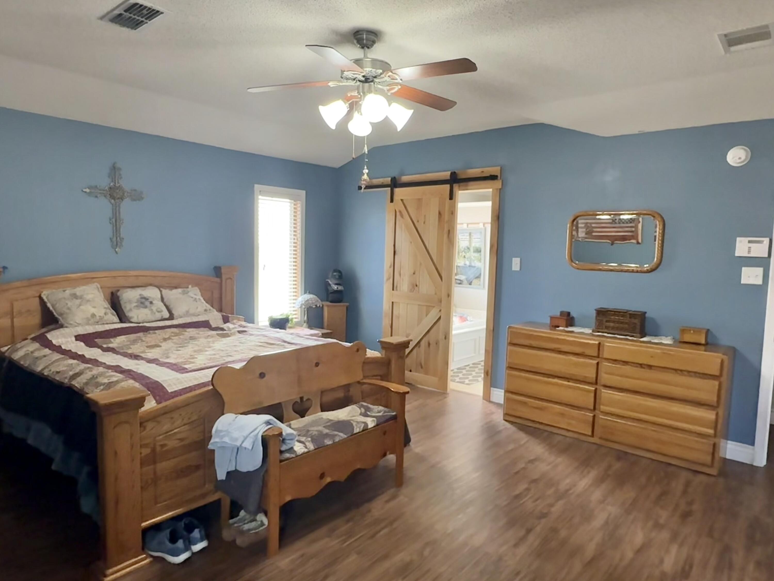 19 Ridgeview Farwell, TX 79325 - Photo 17 of 40 a bedroom with a bed and a chandelier