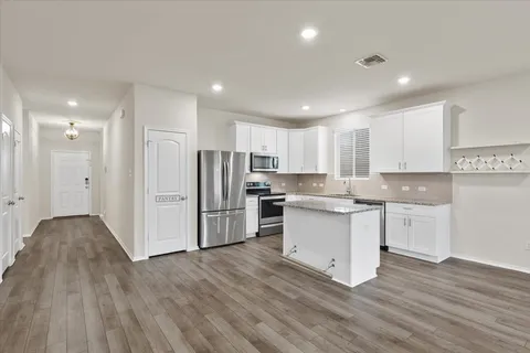 a kitchen with stainless steel appliances granite countertop a refrigerator and a stove top oven