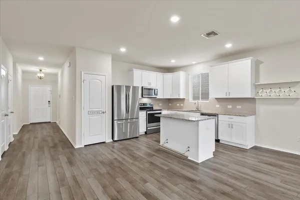 a kitchen with stainless steel appliances granite countertop a refrigerator and a stove top oven