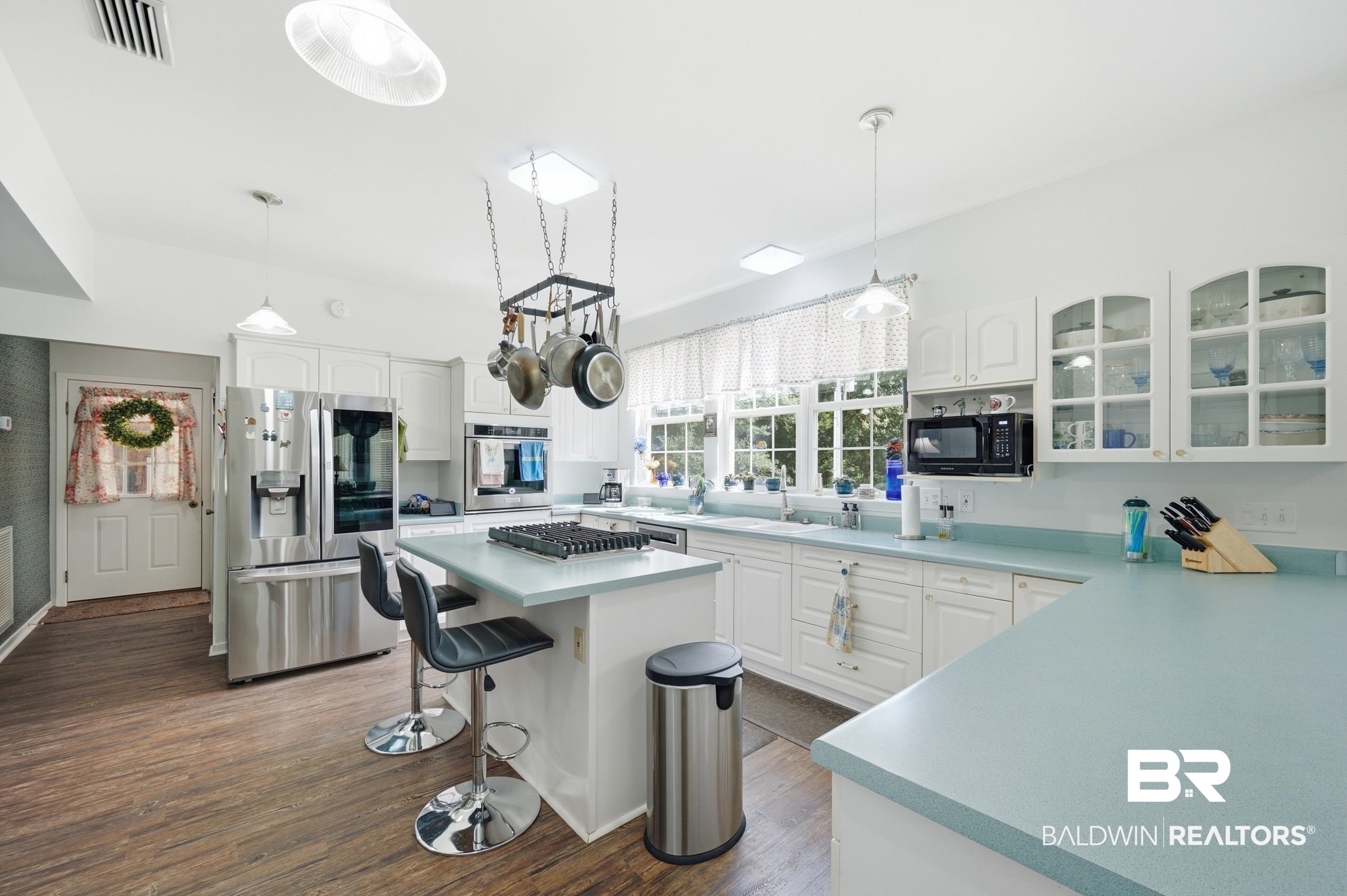 15855 Calvin Richerson Road Bay Minette, AL 36507 - Photo 23 of 83 Bright kitchen featuring white cabinetry, light blue countertops, wood-finish flooring, stainless steel appliances, and a central island with a gas cooktop