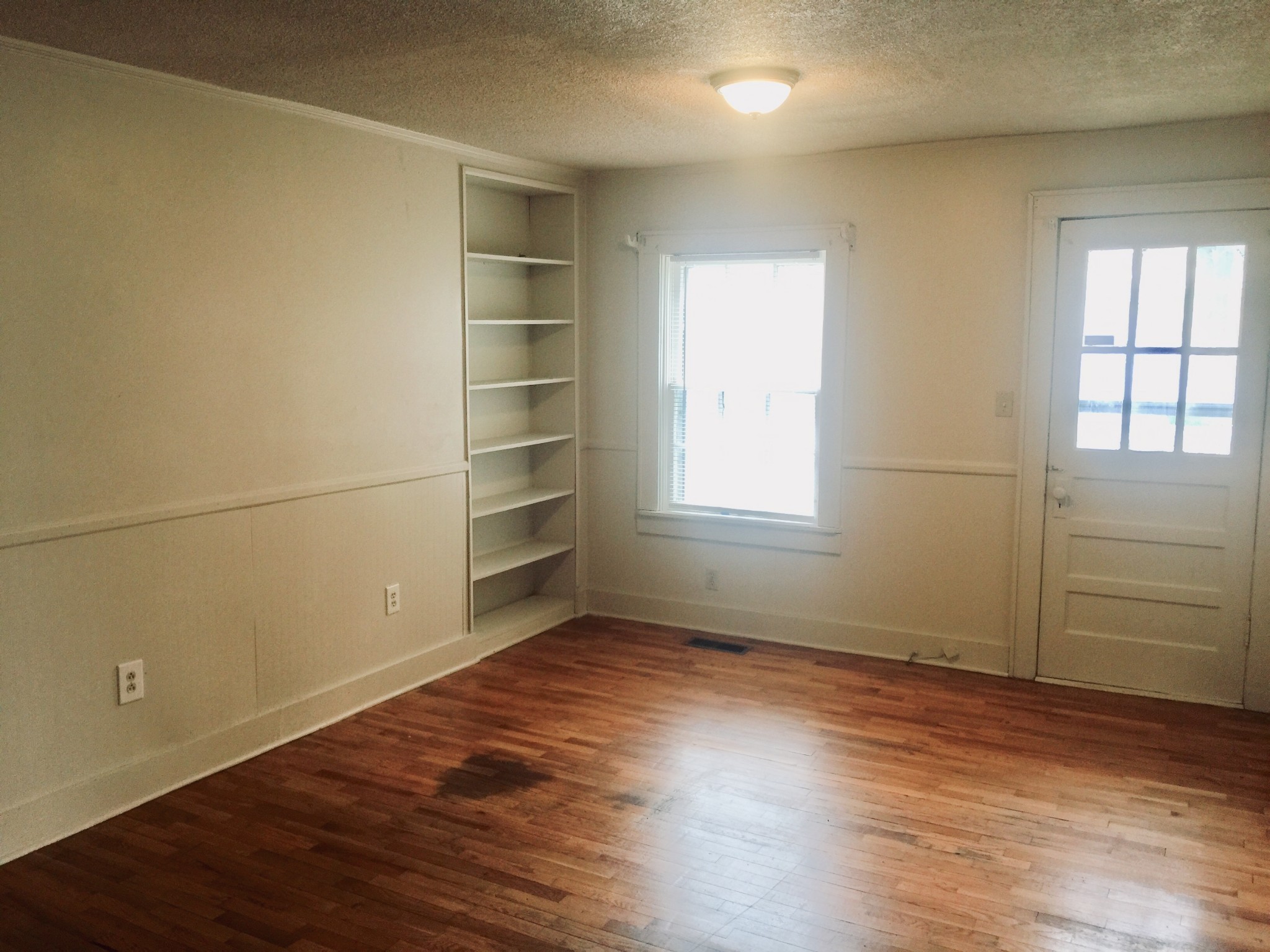 451 East Madison Street Pulaski, TN 38478 - Photo 11 of 16 an empty room with wooden floor and windows