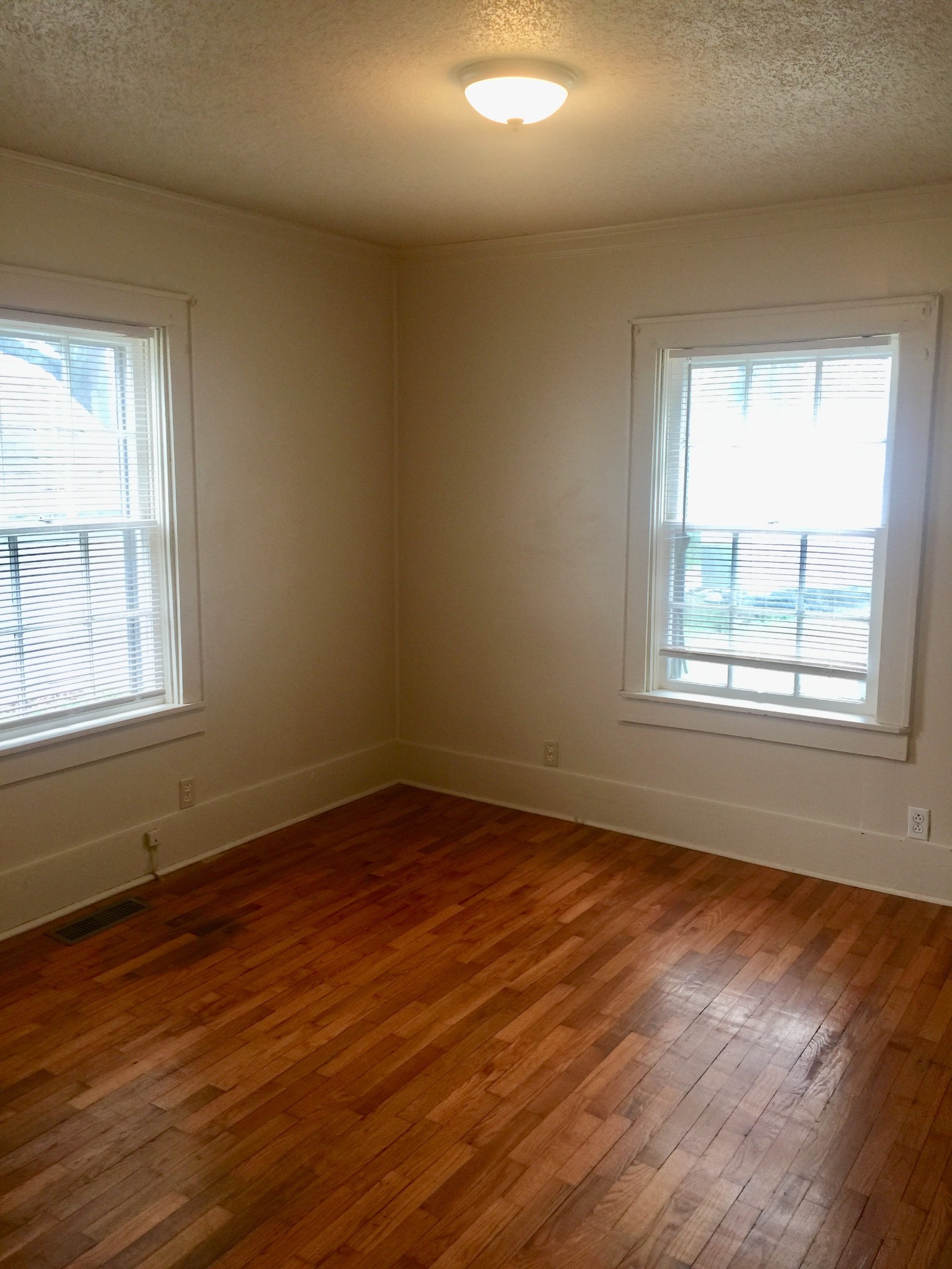 451 East Madison Street Pulaski, TN 38478 - Photo 12 of 16 a view of an empty room with wooden floor and a window