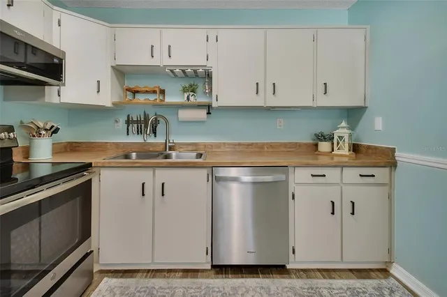 a kitchen with white cabinets and white appliances
