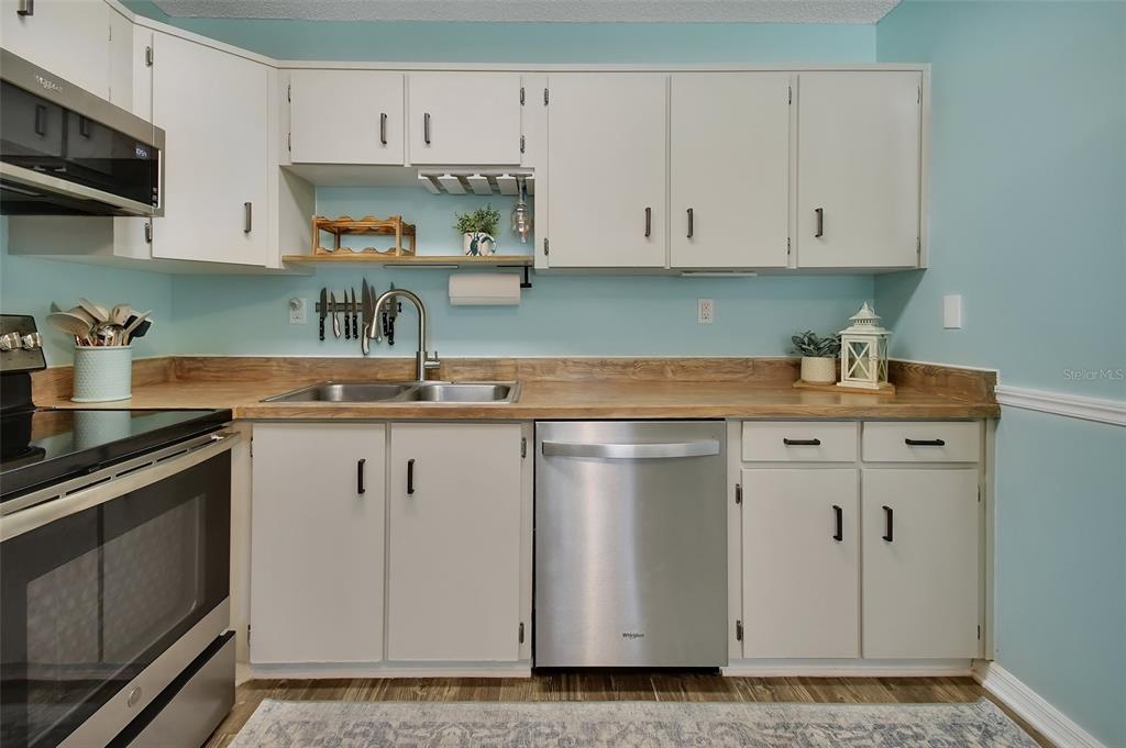 1601 Big Tree Road, Unit 307 South Daytona, FL 32119 - Photo 6 of 18 a kitchen with white cabinets and white appliances