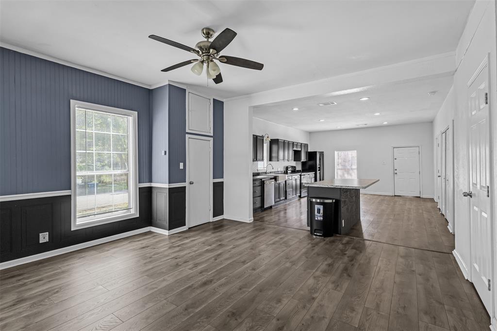 100 West Munson Street Denison, TX 75021 - Photo 2 of 12 a view of a kitchen with furniture a ceiling fan and wooden floor