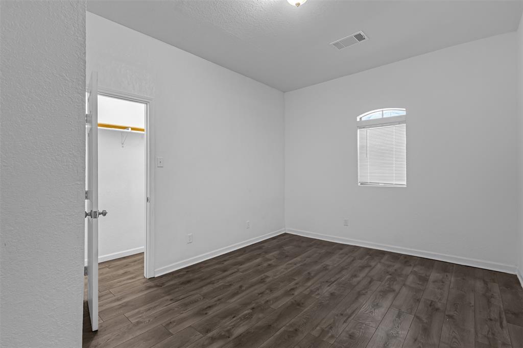 100 West Munson Street Denison, TX 75021 - Photo 9 of 12 an empty room with wooden floor and window