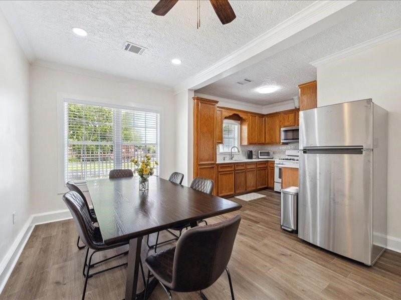 1801 Hussion Street Houston, TX 77003 - Photo 8 of 20 a kitchen with stainless steel appliances granite countertop a stove a refrigerator a microwave a dining table and chairs with wooden floor