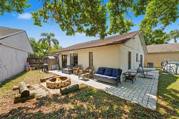 a view of a house with backyard and a tree