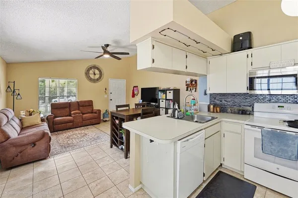 a living room with furniture and kitchen view