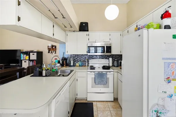 a kitchen with kitchen island white cabinets and white appliances