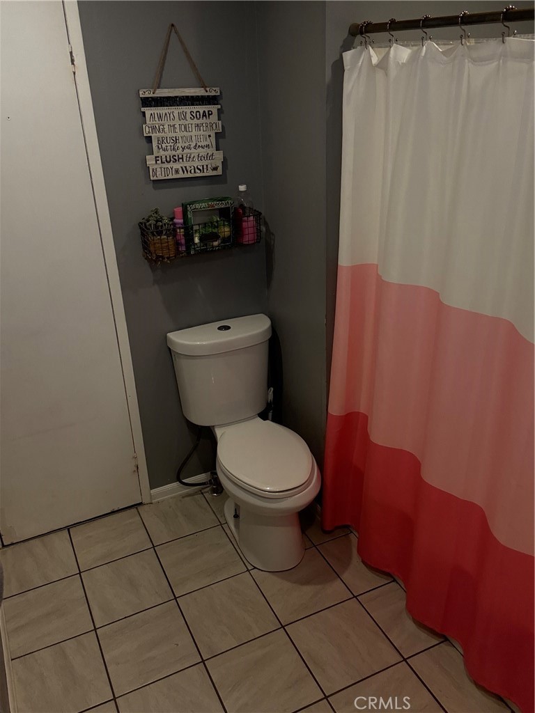 626 Dearborn, Unit 7 Redlands, CA 92374 - Photo 5 of 12 a bathroom with a toilet and a shower curtain