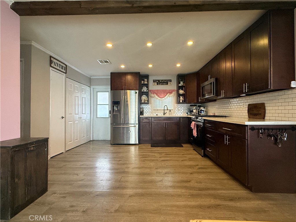 626 Dearborn, Unit 7 Redlands, CA 92374 - Photo 6 of 12 a kitchen with stainless steel appliances kitchen island granite countertop a refrigerator and a stove top oven