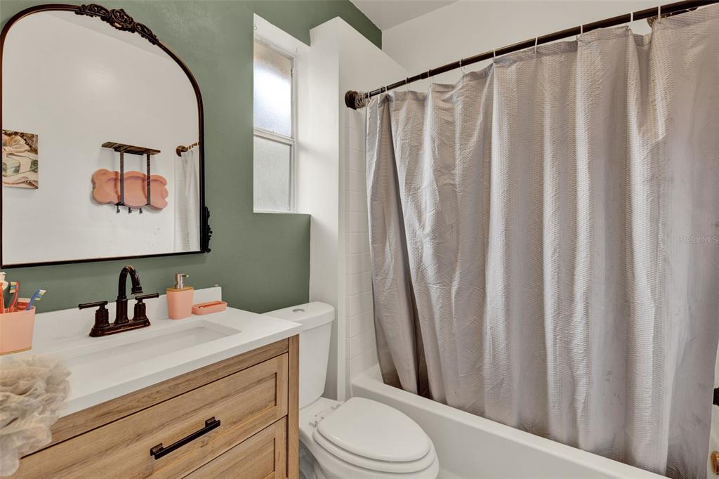 520 Dora Avenue Tavares, FL 32778 - Photo 11 of 17 a bathroom with a sink a toilet a mirror and shower curtain