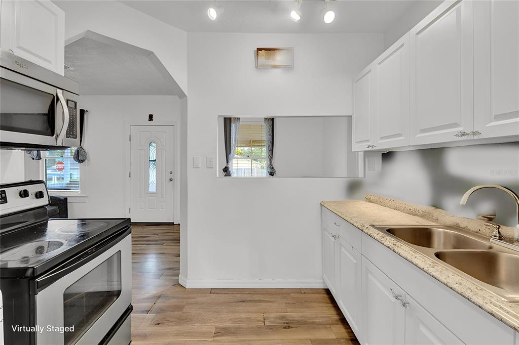 520 Dora Avenue Tavares, FL 32778 - Photo 9 of 17 a kitchen with granite countertop a sink stainless steel appliances and cabinets