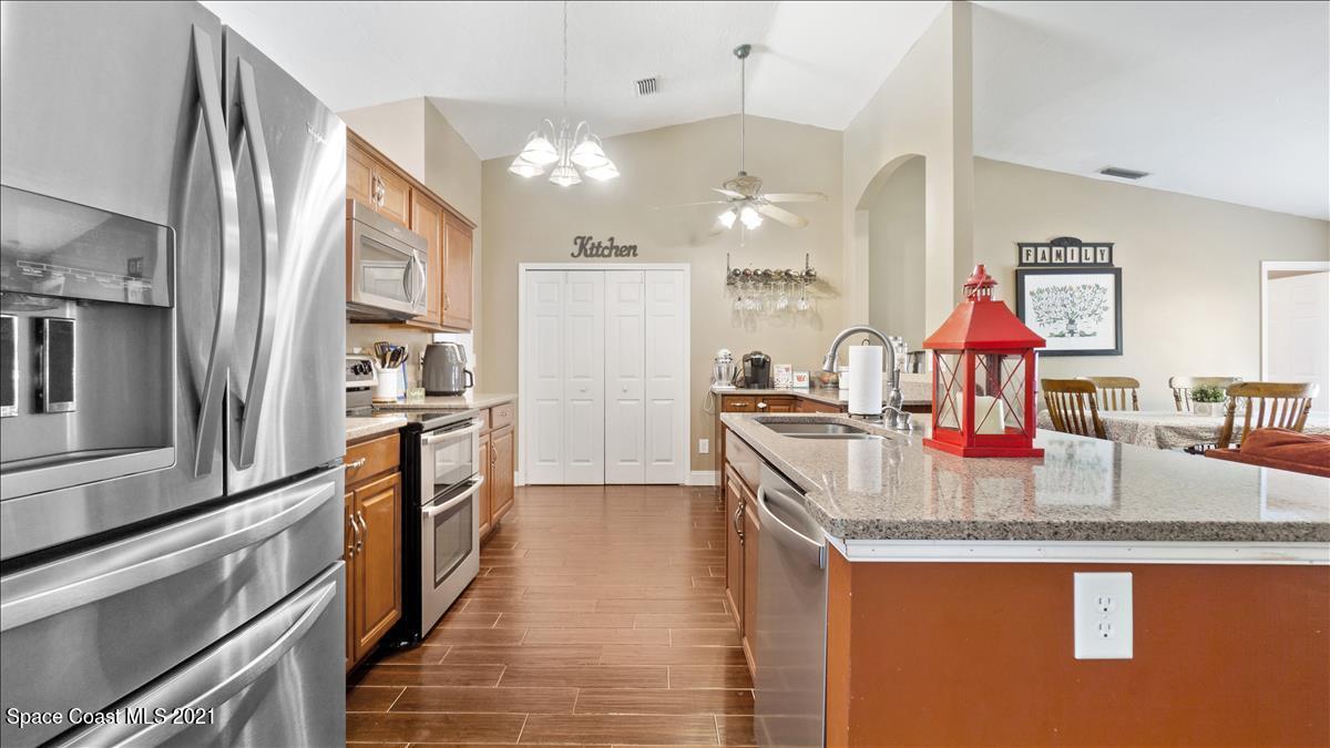 7220 Freeport Road Cocoa, FL 32927 - Photo 12 of 25 a kitchen with stainless steel appliances granite countertop a sink a stove and a refrigerator