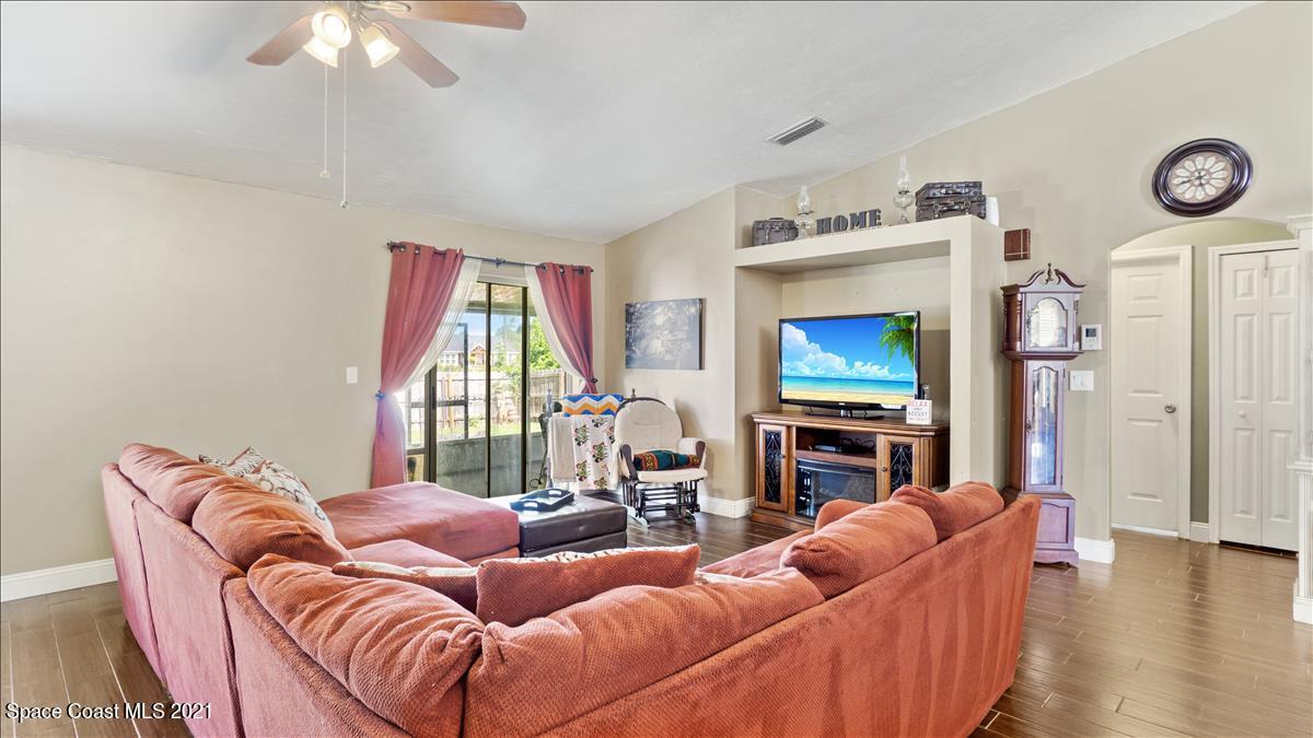 7220 Freeport Road Cocoa, FL 32927 - Photo 13 of 25 a living room with furniture a fireplace and a flat screen tv