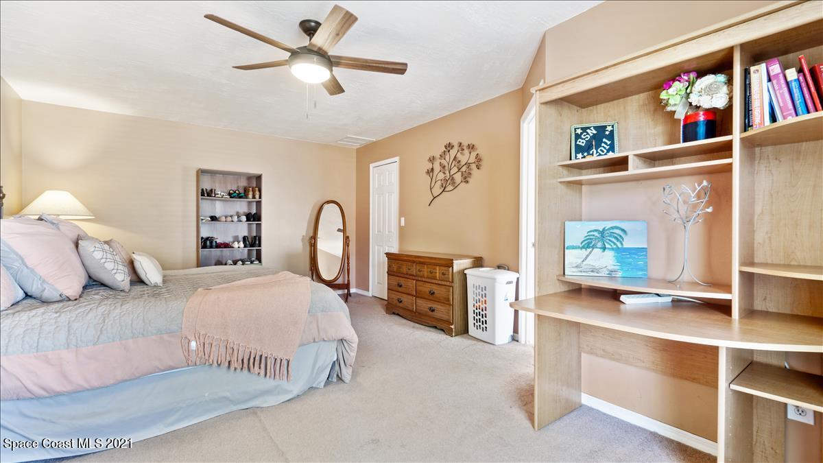 7220 Freeport Road Cocoa, FL 32927 - Photo 25 of 25 a bedroom with a bed bookshelf and a large window