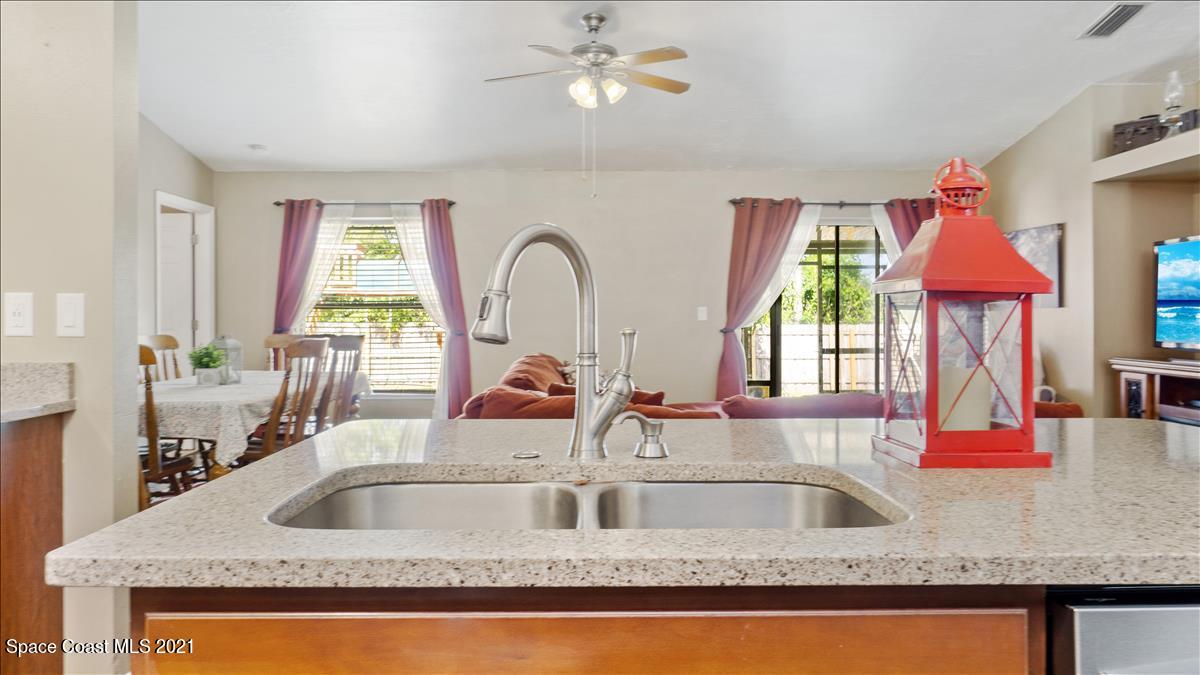 7220 Freeport Road Cocoa, FL 32927 - Photo 9 of 25 a kitchen sink with granite countertop a sink a window and cabinets