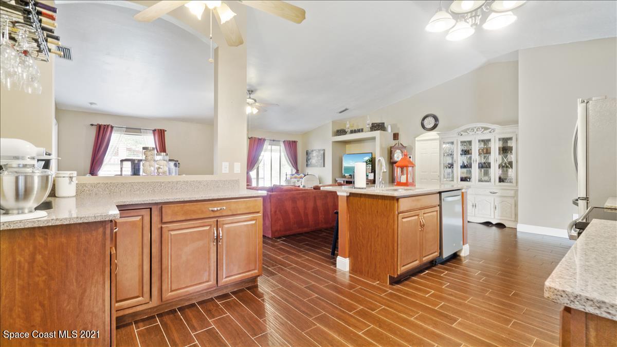 7220 Freeport Road Cocoa, FL 32927 - Photo 10 of 25 a kitchen with granite countertop a sink cabinets and stainless steel appliances