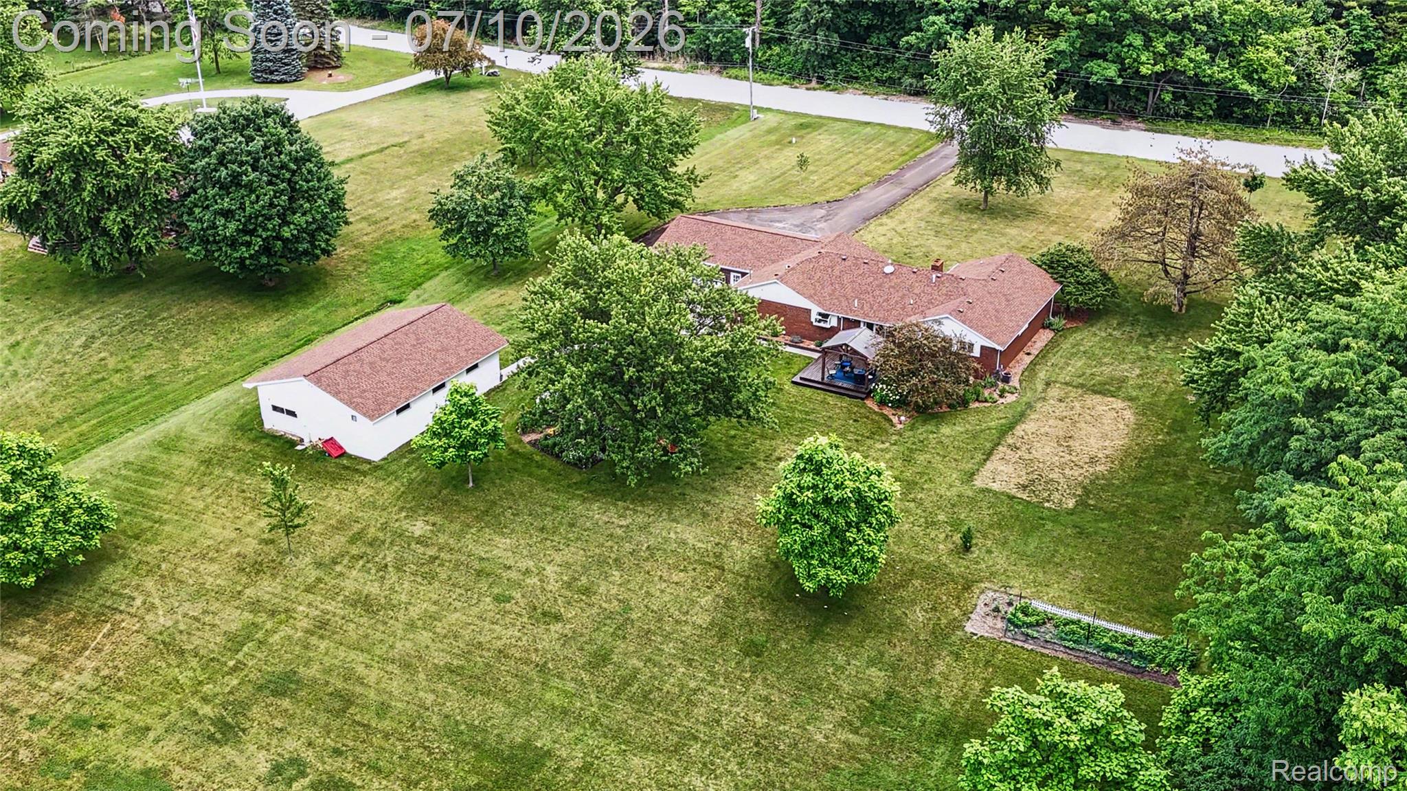 2180 Hurst Road St. Clair, MI 48079 - Photo 38 of 39 Expansive property featuring a single-story residence, a detached auxiliary building, mature trees, a garden bed, and a gravel driveway