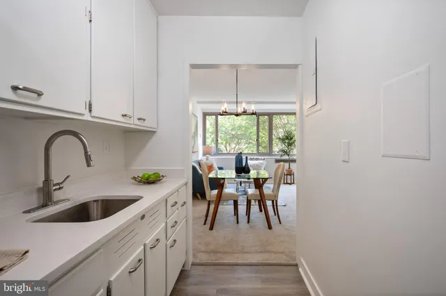 a kitchen with a white cabinets a sink and a window