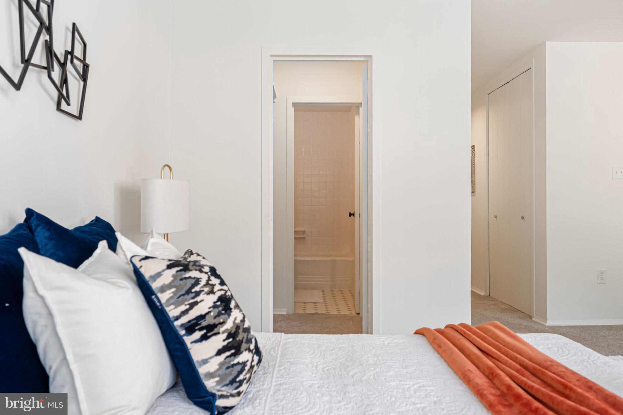 4101 Cathedral Avenue Northwest, Unit 616 Washington, DC 20016 - Photo 12 of 27 a bedroom with a bed and a chandelier