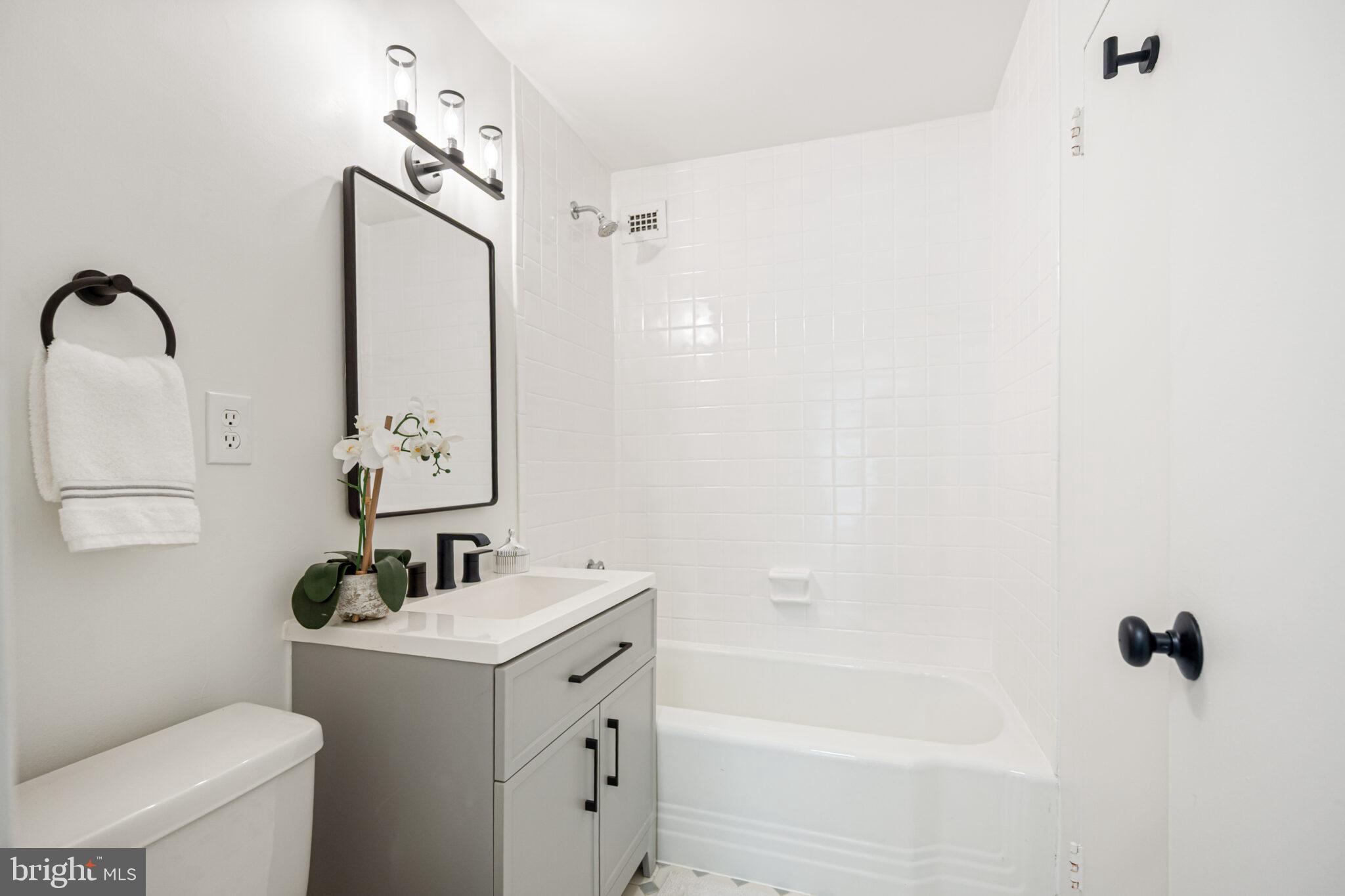 4101 Cathedral Avenue Northwest, Unit 616 Washington, DC 20016 - Photo 14 of 27 a bathroom with a granite countertop sink toilet and shower