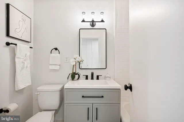 a bathroom with a sink and mirror with toilet