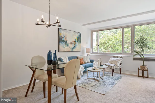 a view of a livingroom and a dining room with furniture window and outside view