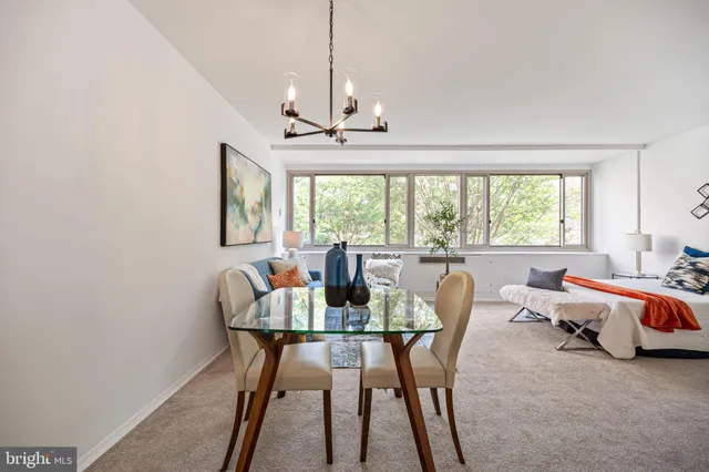 a dining room with furniture a chandelier and wooden floor