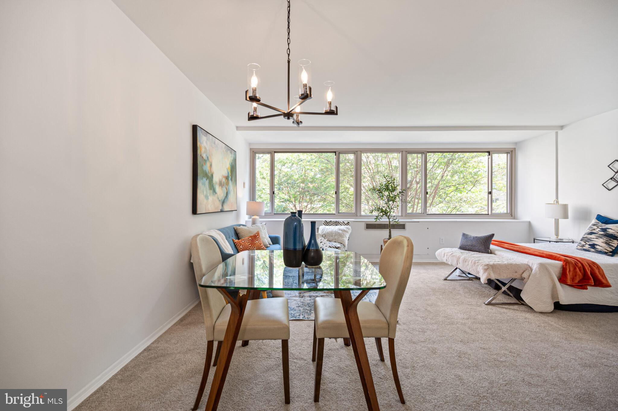 4101 Cathedral Avenue Northwest, Unit 616 Washington, DC 20016 - Photo 6 of 27 a dining room with furniture a chandelier and wooden floor