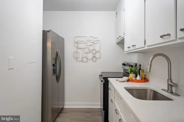 a kitchen with stainless steel appliances kitchen island a refrigerator sink and cabinets