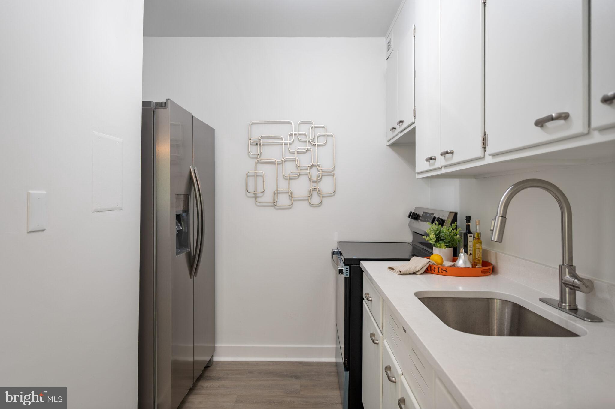 4101 Cathedral Avenue Northwest, Unit 616 Washington, DC 20016 - Photo 8 of 27 a kitchen with stainless steel appliances kitchen island a refrigerator sink and cabinets