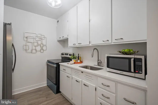 a kitchen with stainless steel appliances white cabinets and a refrigerator
