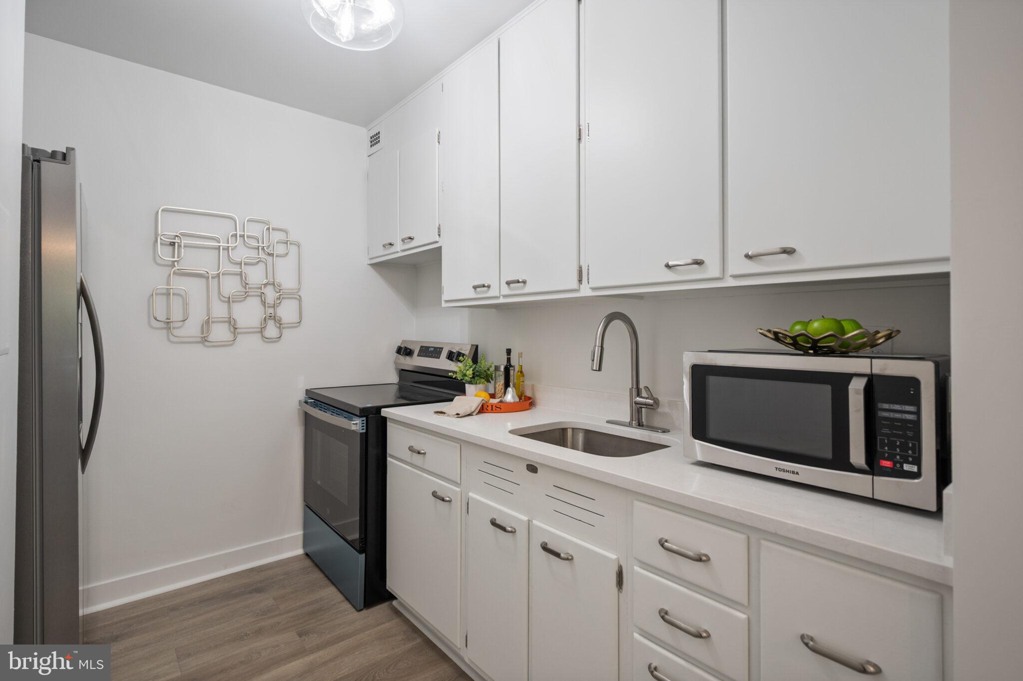4101 Cathedral Avenue Northwest, Unit 616 Washington, DC 20016 - Photo 10 of 27 a kitchen with stainless steel appliances white cabinets and a refrigerator