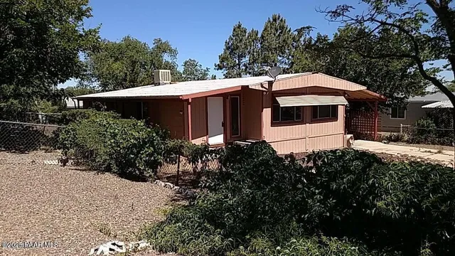 a view of a house with a yard and potted plants