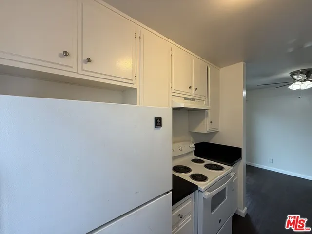 a kitchen with white cabinets and white appliances